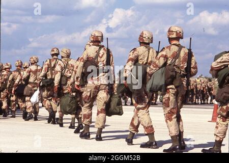 Fort Hood Texas USA, 1990: I soldati dell'esercito degli Stati Uniti che indossano uniformi di camouflage color deserto e trasportano armi e attrezzature si preparano a salire a bordo degli aerei sulla strada per servire nel conflitto in Medio Oriente. ©Bob Daemmrich Foto Stock