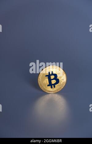 Una moneta di colore oro Bitcoin con la lettera 'B' di colore blu, centrata su sfondo grigio scuro. Bitcoin - BTC bit Coin - Crypto valuta. Foto Stock