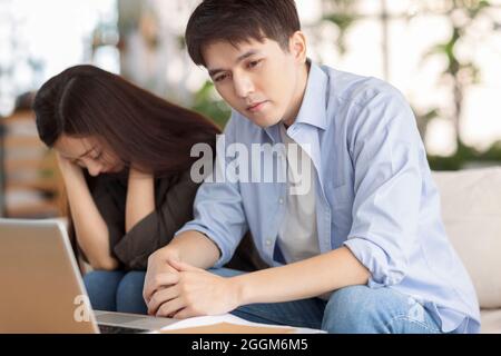 coppia stressata usando il laptop a casa. Foto Stock