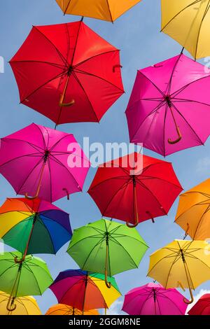 Ombrelloni colorati contro un cielo blu a Masevaux in Alsazia, Francia Foto Stock