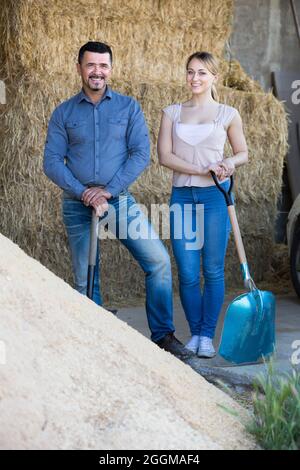 Due operai agricoli che tengono le pale grandi Foto Stock