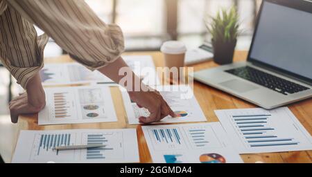 Uomo d'affari che discute le tabelle o i grafici di analisi sul tavolo da tavolo e usando il computer portatile.Chiudi l'analisi maschile e il concetto di strategia. Foto Stock