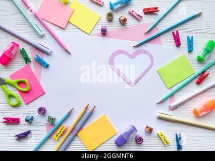 Cornice di cancelleria diversa su sfondo bianco di legno, piatto con spazio per il testo. Torna a scuola Foto Stock