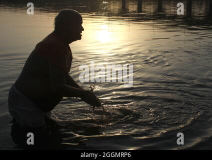 I devoti indù eseguono 'Tarpan', o rituali di Pind Daan per la pace delle anime degli antenati, sulla riva di Yamuna a Nuova Delhi. Foto Stock