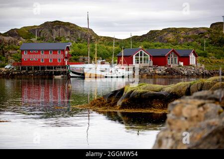 Tipiche cabine di pesca Rourbuer nel villaggio di Lofoten in una giornata piovosa, in estate. Tradizionale norvegese casa di legno rorbuer Foto Stock