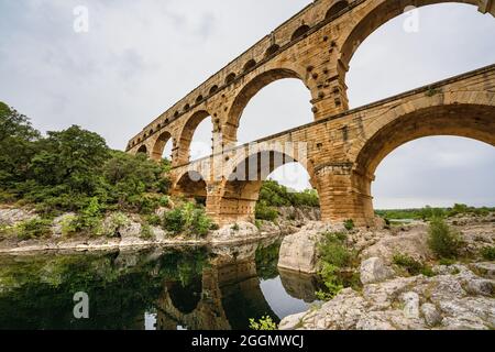 Vista ad angolo basso di un acquedotto dell'Impero Romano, Pont du Gard in Francia. Ingegneria antica civilizzazione per approvvigionamento idrico. Foto Stock