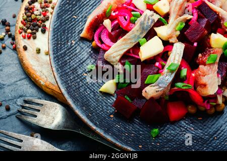 Insalata con aringhe, barbabietole, cipolle e piselli verdi. Insalata russa tradizionale Foto Stock