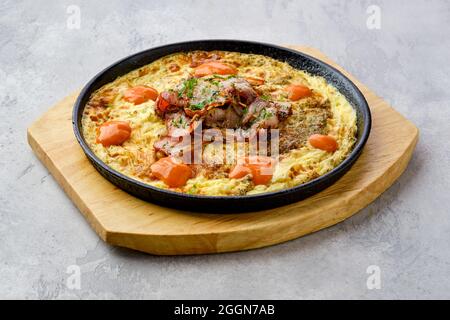Uova con pancetta e pomodoro cotte in forno in padella in ghisa Foto Stock