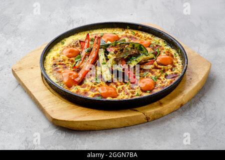 Uova al peperone e zucchine cotte in forno in padella in ghisa Foto Stock