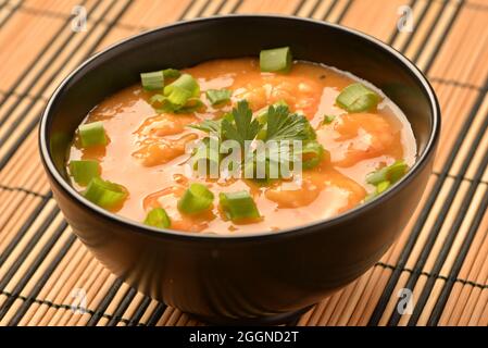 moqueca di gamberi con erba cipollina, prezzemolo e pepe. Foto Stock