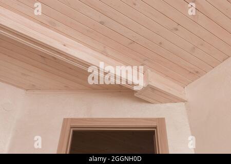 Porta negli interni moderni della camera con soffitto in legno. Foto Stock