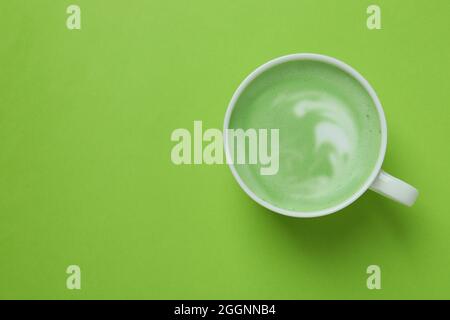Tazza di latte matcha su sfondo verde Foto Stock