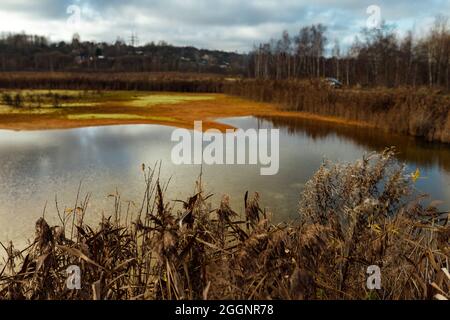 il tubo scarica i rifiuti nell'acqua. contaminazione del serbatoio con sostanze tossiche pericolose. fuoriuscita di olio sull'acqua. le fabbriche scaricano il pollu Foto Stock