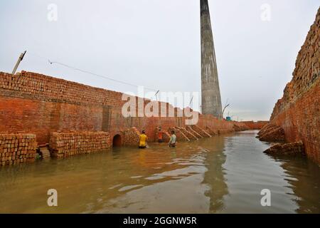 Munshiganj City, Bangladesh. 01 Settembre 2021. MUNSHIGANJ CITY, BANGLADESH- 1 SETTEMBRE: Un migrante del Bangladesh tiene blocchi di mattoni sopra la sua testa per trasportarla sull'altro lato del fiume ad un mattone-campo in Dhaka. Circa 400,000 migranti a basso reddito arrivano a Dhaka ogni anno per lavorare a brickfields, nella fabbrica di mattoni milioni di mattoni vengono bruciati anche se questo influisce sull'ambiente in Bangladesh. Il 1 settembre 2021 a Munshiganj City, Bangladesh. (Foto di Harun-or-Rashid/Eyepix Group) (Foto di Eyepix/Sipa USA) Credit: Sipa USA/Alamy Live News Foto Stock