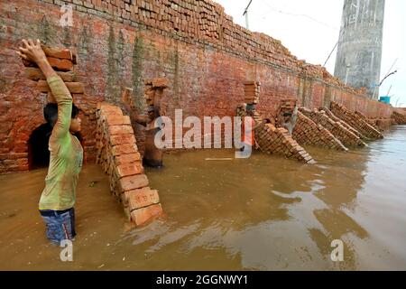 Munshiganj City, Bangladesh. 01 Settembre 2021. MUNSHIGANJ CITY, BANGLADESH- 1 SETTEMBRE: Un migrante del Bangladesh tiene blocchi di mattoni sopra la sua testa per trasportarla sull'altro lato del fiume ad un mattone-campo in Dhaka. Circa 400,000 migranti a basso reddito arrivano a Dhaka ogni anno per lavorare a brickfields, nella fabbrica di mattoni milioni di mattoni vengono bruciati anche se questo influisce sull'ambiente in Bangladesh. Il 1 settembre 2021 a Munshiganj City, Bangladesh. (Foto di Harun-or-Rashid/Eyepix Group) (Foto di Eyepix/Sipa USA) Credit: Sipa USA/Alamy Live News Foto Stock