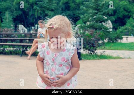 Bambino stomaco Ache. Mani sul ventre. Mano sullo stomaco perché indigestione, malattia dolorosa sensazione di malessere. Foto Stock