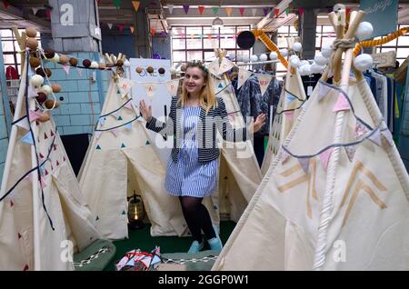 Mercato delle pulci. Donna venditore in piedi al banco vendita di wigwams bambini fatti a mano. Settembre 26, 2019. Kiev, Ucraina Foto Stock