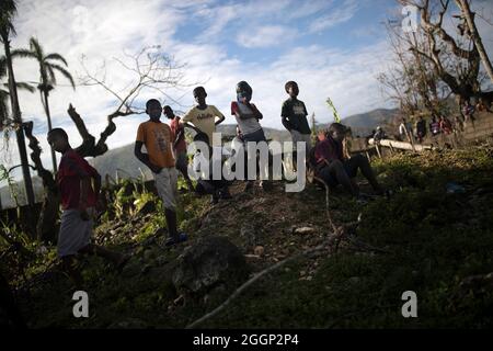 I bambini si riuniscono per guardare Marines e marinai offload oltre mille libbre di riso da un CH-53 Super Stallion elicottero in Plaisance du Sud, un comune ad Anse-à-vitello Arrondissement nel dipartimento di Nippes di Haiti dal 18 ottobre 2016. Haiti è stato sbattuto dall uragano Matteo una categoria 4 tempesta che ha colpito i Caraibi in precedenza in ottobre. Il ventiquattresimo Marine Expeditionary Unit, sotto la Joint Task Force Matteo, assistita di organizzazioni governative e non governative nel fornire aiuti umanitari per Haiti nella tempesta di scia. (U.S. Marine Corps foto di Sgt. Matthew Callahan) Foto Stock