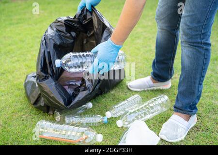 Donna asiatica volontario trasportare bottiglie di plastica di acqua in sacchetto di rifiuti rifiuti rifiuti in parco, riciclare ambiente ecologia concetto. Foto Stock