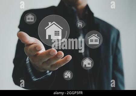 Comprare, vendere e affittare case o concetto di bene immobile, proprietà online, uomo d'affari mani su un concetto di schermo virtuale. Foto Stock