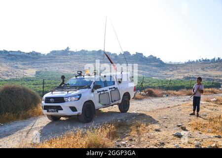 Dal 2004 i bambini del villaggio di Tuba stanno andando a scuola nel vicino villaggio di AT-Tuwani, 2.6 km di distanza - mentre sono stati condotti da un attivista ebraico e un veicolo delle forze di difesa israeliane per proteggerli dagli attacchi violenti da parte dei coloni ebrei religiosi dall'avamposto illegale di Maon Farm, che si trova sul loro cammino verso la scuola. Palestina/Israele, a sud di Hebron. 31 agosto 2021. (Foto di Matan Golan/Sipa USA) Credit: Sipa USA/Alamy Live News Foto Stock