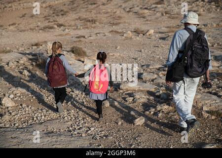 Dal 2004 i bambini del villaggio di Tuba stanno andando a scuola nel vicino villaggio di AT-Tuwani, 2.6 km di distanza - mentre sono stati condotti da un attivista ebraico e un veicolo delle forze di difesa israeliane per proteggerli dagli attacchi violenti da parte dei coloni ebrei religiosi dall'avamposto illegale di Maon Farm, che si trova sul loro cammino verso la scuola. Palestina/Israele, a sud di Hebron. 31 agosto 2021. (Foto di Matan Golan/Sipa USA) Credit: Sipa USA/Alamy Live News Foto Stock