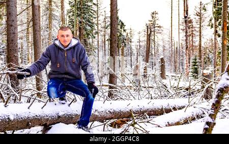 Uomo viaggiatore e escursionista nella foresta d'argento morente e nevicato in abeti morti e paesaggio Brocken Harz Germania Foto Stock