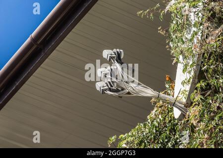 Ricevitore di segnale TV satellitare e antenna TV vicino al tetto della casa contro il cielo. Foto Stock