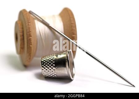 Ago per cucire e filo su fondo bianco Foto Stock