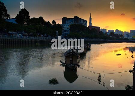 Huts galleggianti sul fiume e Skyline di Saigon al tramonto, ho chi Minh City, Vietnam Foto Stock