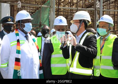 (210902) -- HARARE, 2 settembre 2021 (Xinhua) -- il presidente dello Zimbabwe Emmerson Mnangagwa (1° L, fronte) parla con il project manager Wei Wei (2° R) nel cantiere del progetto di espansione dell'aeroporto internazionale Robert Gabriel Mugabe di Harare, Zimbabwe, 1° settembre 2021. Il completamento dell'espansione dell'aeroporto internazionale Robert Gabriel Mugabe aumenterà significativamente gli arrivi turistici, ha detto mercoledì il presidente dello Zimbabwe Emmerson Mnangagwa. Il progetto, intrapreso da China Jiangsu International, un appaltatore cinese, è in corso nonostante i ritardi causati dalla pandemia del COVID-19. (Foto di Foto Stock