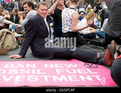 Un protestore ha ritratto seduto in strada dietro una bandiera che dice 'DIVIETO DI INVESTIMENTO DI COMBUSTIBILI FOSSILI' come Extinction Rebellion prendere spazio fuori della Banca d'Inghilterra durante la loro protesta di Mass Bail Break l'undicesimo giorno delle loro proteste impossibili della ribellione a Londra, Regno Unito il 2 settembre 2021. I manifestanti arrestati durante l'impossibile ribellione sono stati incoraggiati a condividere le loro storie durante tutto il giorno. Foto Stock