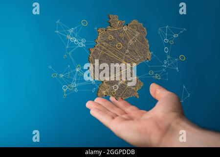 Primo piano di una mappa di rendering 3D della Germania con cifre binarie sulla mano di un uomo Foto Stock