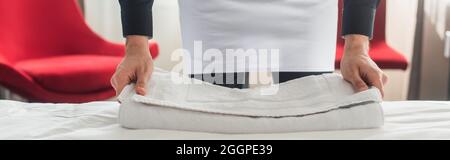 la vista era districata del padrone di casa e gli asciugamani erano puliti sul letto della camera d'albergo, il banner Foto Stock