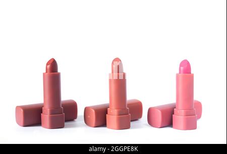 Rossetti di moda in rosso, marrone e rosa isolati su sfondo bianco, foto studio. Bella make-up o concetto di vendita cosmetica Foto Stock