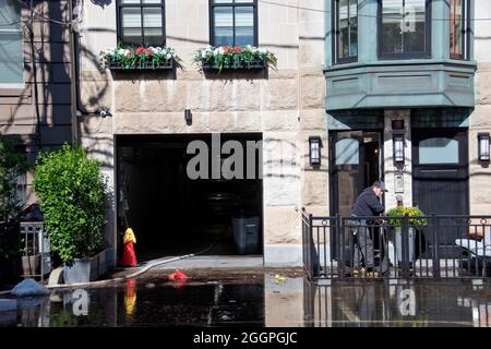 Un uomo si ripulisce dalle inondazioni causate dall'uragano Ida a Hoboken, New Jersey, USA. Foto Stock