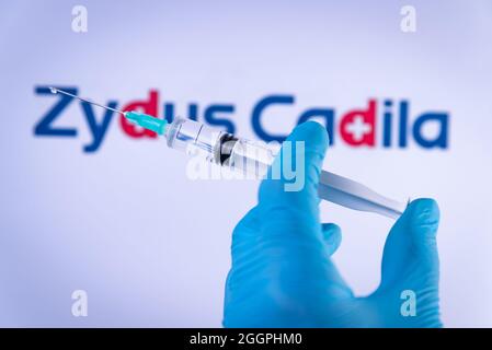 In questa foto illustrazione una mano in guanti medici tenere una siringa di fronte al logo Zydus Cadila a Barcellona, Spagna il 2 settembre 2021. Zydus Cadel Foto Stock