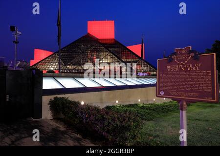 La vista notturna della Roll and Roll Hall of Fame disegnata dall'architetto I.M.Pei con lo storico luogo di nascita dell'Ohio Marker di Rock 'n' Roll in primo piano.Cleveland.Ohio.USA Foto Stock