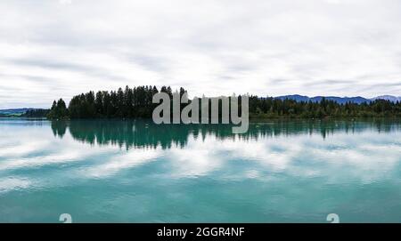 Lech Reservoir a Lechbruck am See. Vista sul lago con la natura circostante. Riflessione nell'acqua. Foto Stock