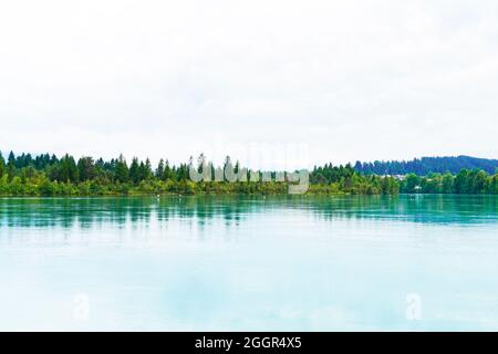 Lech Reservoir a Lechbruck am See. Vista sul lago con la natura circostante. Riflessione nell'acqua. Foto Stock