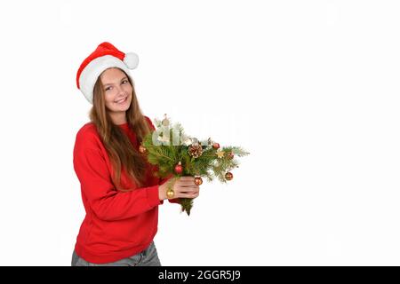 Ragazza allegra in cappello santa che indossa un pullover rosso con rami di albero di natale Foto Stock