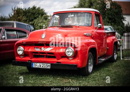 DIEDERSDORF, GERMANIA - 21 AGOSTO 2021: Autocarro a pieno carico Ford F-100 (seconda generazione), 1953. Concentrarsi sul centro. Bokeh vorticoso. La mostra di Foto Stock