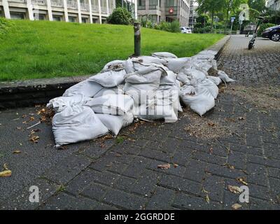 Sacchi di sabbia che giacciono sulla strada come resti di un'enorme inondazione del fiume Ruhr a Mülheim Foto Stock