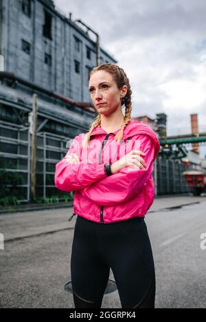 Sportswoman con trecce boxer in posa davanti ad una fabbrica Foto Stock