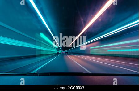 Vista frontale del conducente, guida veloce in un tunnel da var con un sacco di luci sfocate. Foto Stock