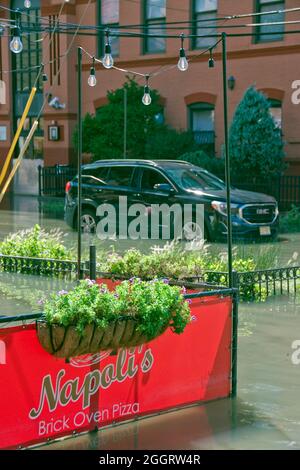 I posti a sedere all'aperto di un ristorante italiano sono inondati dalla pioggia proveniente dall'uragano Ida a Hoboken, New Jersey, USA. Foto Stock