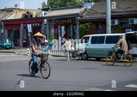 Pechino, Cina. 2 settembre 2021. Un uomo che indossa un tradizionale cappello di paglia corre in bicicletta lungo Wangfujing Street a Pechino, Cina il 02/09/2021 da Wiktor Dabkowski Credit: dpa/Alamy Live News Foto Stock