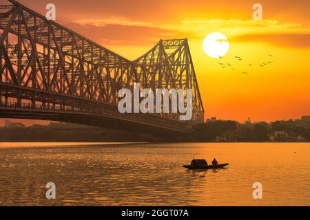 Ponte Howrah con barca da pesca sul fiume Ganges all'alba a Kolkata India Foto Stock