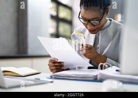 Avvocato che esamina la carta utilizzando lente d'ingrandimento. Indagine sulle frodi fiscali Foto Stock