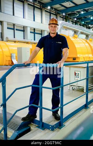 Karlsruhe, Germania. 18 ago 2021. Mike Reddmann, caposquadra della società energetica EnBW, si trova di fronte alla turbina nell'unità 8 della centrale a vapore Rheinhafen di Karlsruhe (RDK 8). La vita quotidiana in una centrale elettrica è di routine. La tensione aumenta quando vengono ricevuti i rapporti di malfunzionamento. Per i lavoratori delle centrali elettriche, vi è un'ulteriore complicazione: Cambi di turno costanti, compreso il lavoro notturno. (A dpa-KORR.: 'Turno di lavoro nella centrale elettrica: A volte solo 20 secondi per reagire') credito: Uwe Anspach/dpa/Alamy Live News Foto Stock